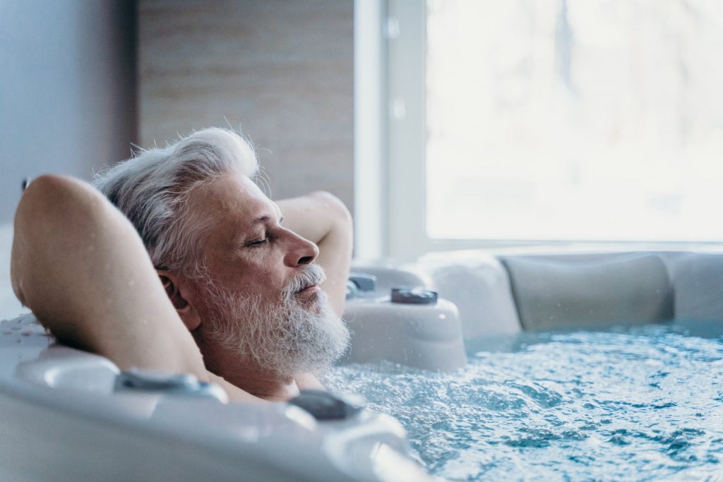 Gezellig stel geniet van hun jacuzzi - waarom je een jacuzzi wilt hebben voor ontspanning en gezondheid