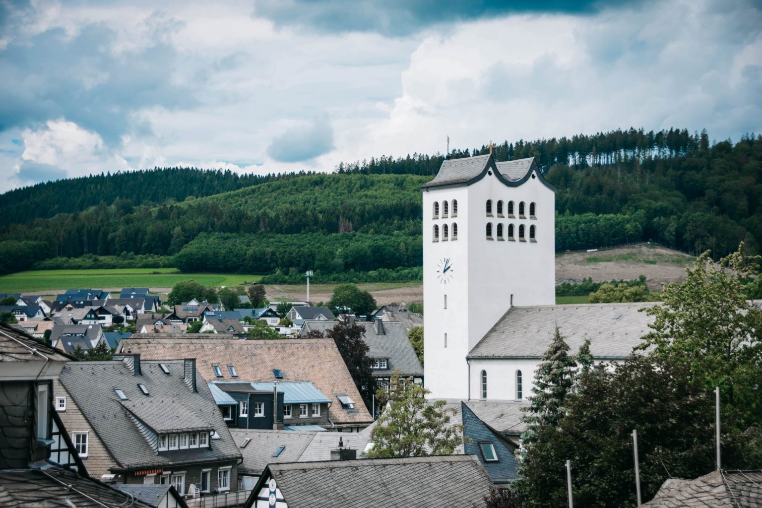 Balkonuitzicht Parkhotel Schmallenberg in Sauerland met natuurpanorama van heuvels en weilanden