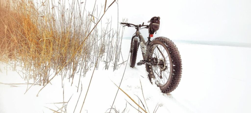 Persoon rijdend op fatbike in Nederlandse sneeuw met brede banden voor grip en stabiliteit