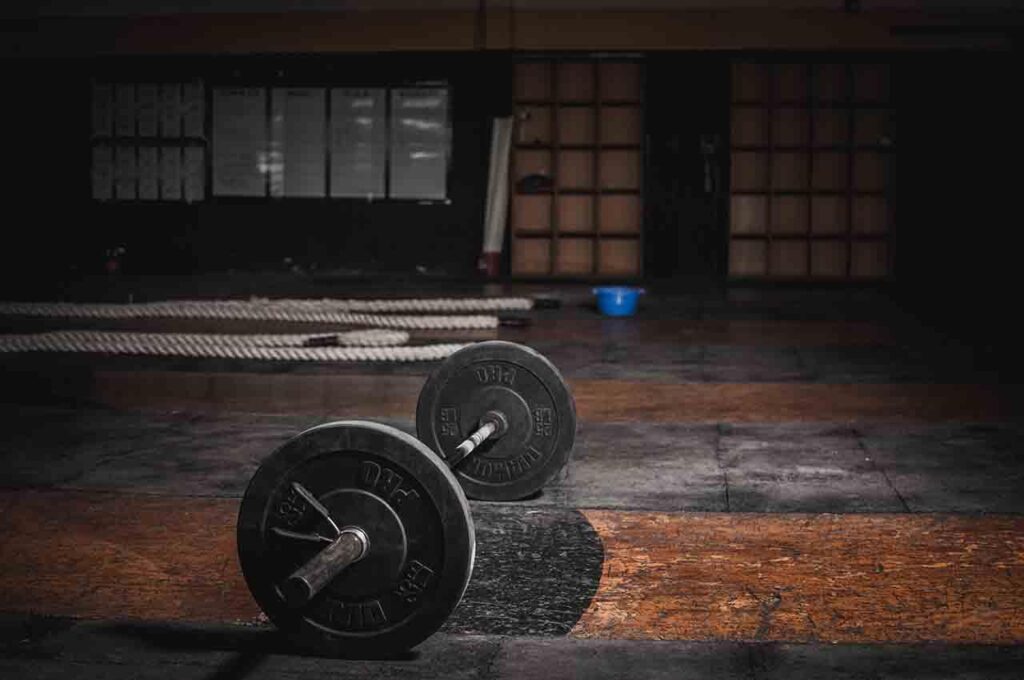 Man traint thuis met gewichten - voordelen van thuis fitnessen inclusief flexibiliteit en comfort