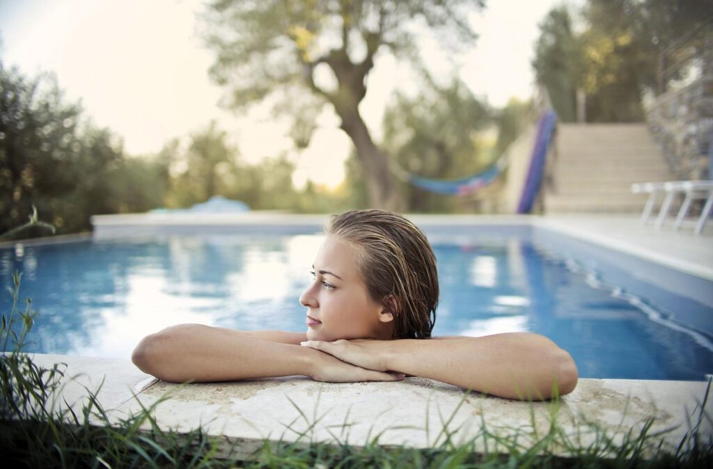 Luxe zwembad in tuin met helder water, omgeven door groene landschapsinrichting en terras
