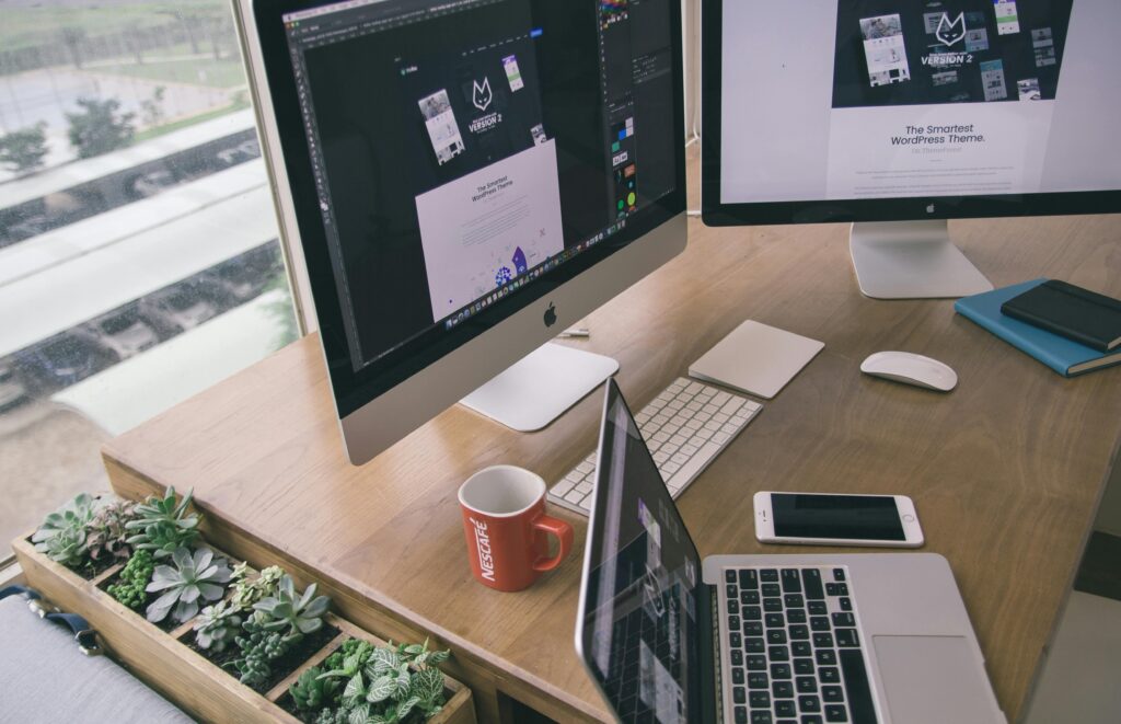 Laptop vs desktop vergelijking: persoon werkt aan een laptop en desktop computer op kantoor