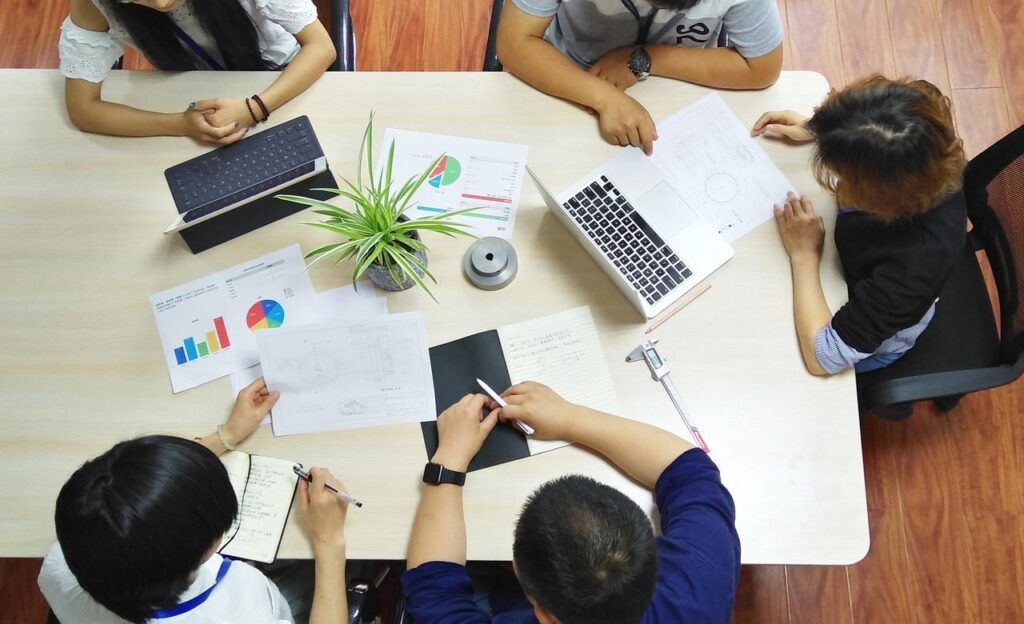 Teamleden in vergaderingssituatie die het belang van vergaderen illustreren voor organisatie en samenwerking