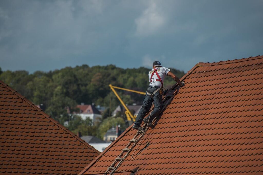 Professionele dakdekker voert dakwerk uit ter bescherming van het huis tegen weersinvloeden