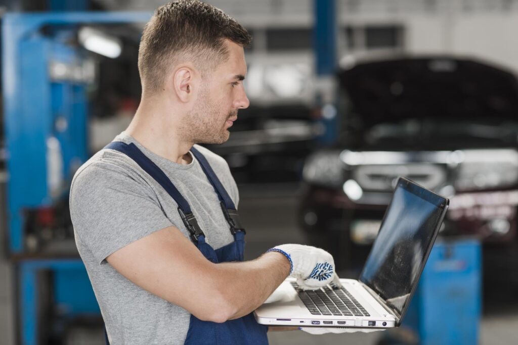 Moderne automonteur werkt met garagesoftware voor digitalisering van garagebedrijf